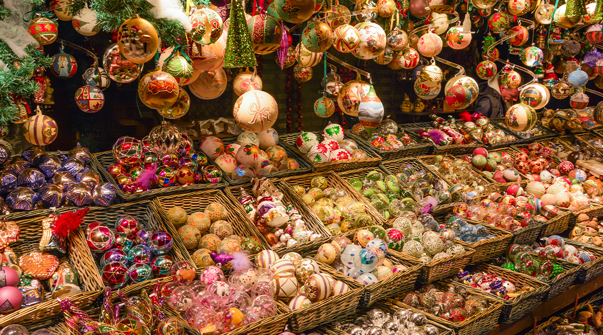 Christmas baubles in baskets and hanging from ceiling of market stall
